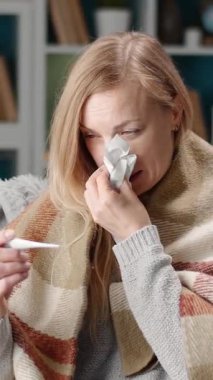 Bir kadın yağmur sırasında soğuk algınlığı ve grip belirtileriyle uğraşır..