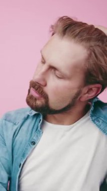 Adam kapalı mekanda kot ceket ve pembe bir maske giyerken samimi bir anın tadını çıkarıyor..