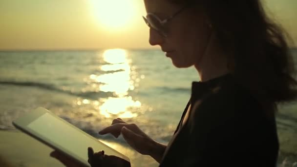 Mujer utiliza Tablet PC en la playa — Vídeo de stock