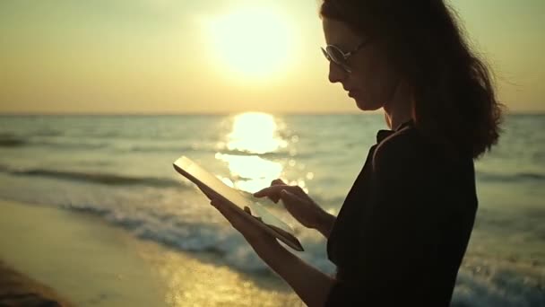 Mujer utiliza Tablet PC en la playa — Vídeo de stock