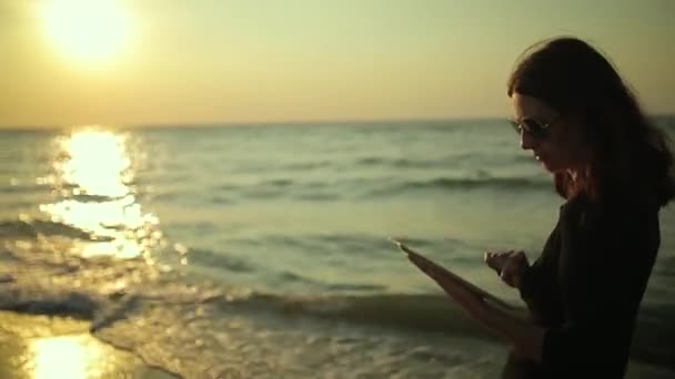 Mujer utiliza Tablet PC en la playa — Vídeo de stock