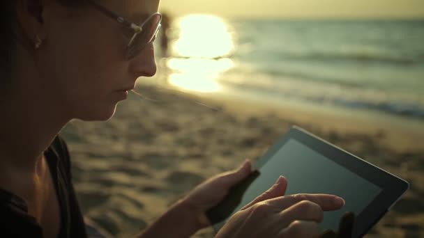 Mujer utiliza Tablet PC en la playa — Vídeo de stock