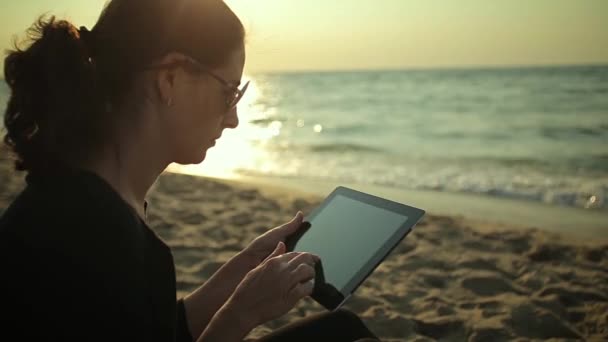 Mujer utiliza Tablet PC en la playa — Vídeo de stock