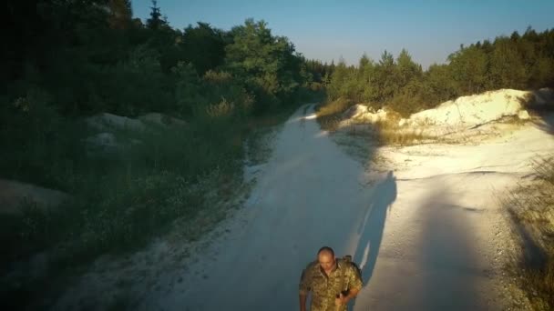 Certo homem militar andar na estrada arenosa — Vídeo de Stock