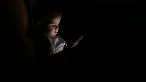 Boy browsing tablet pc in the dark — Stock Video