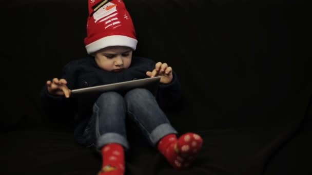 Маленький мальчик с удовольствием держит в руках планшетный компьютер — стоковое видео