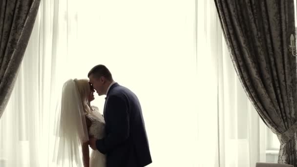 Happy wedding couple near window — Stock Video