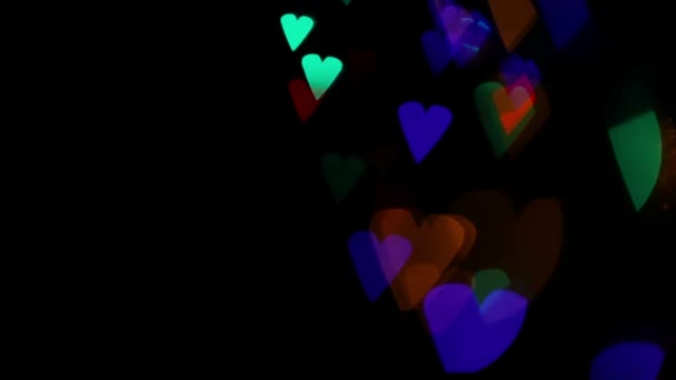 Luci colorate cuore bokeh su nero — Video Stock