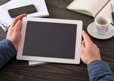 boş ekran ile beyaz bir tablet tutan adam