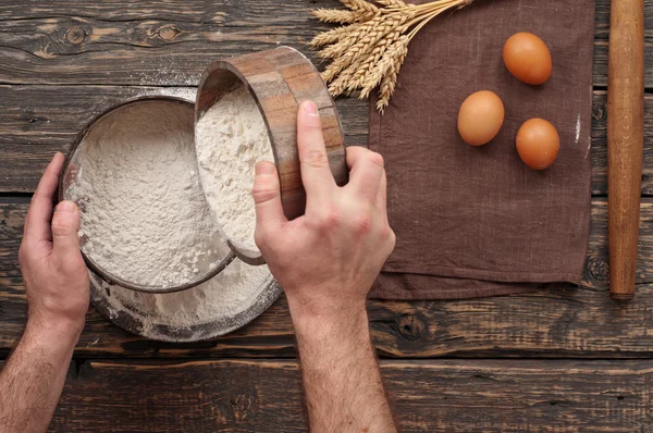 Пекарь просеять муку, чтобы сделать хлеб — стоковое фото