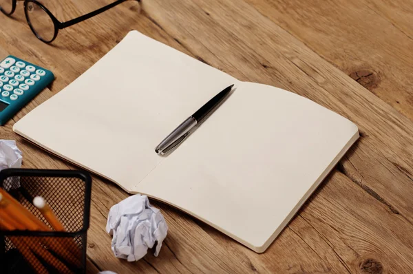 Abra o caderno, caneta, calculadora, óculos na mesa de escritório — Fotografia de Stock