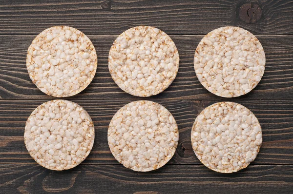 Bolos de arroz redondos dietéticos em um fundo de madeira escura — Fotografia de Stock