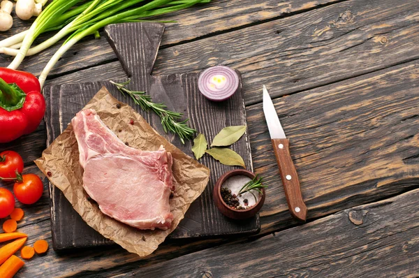 Trozo de cerdo fresco en el hueso con verduras — Foto de Stock