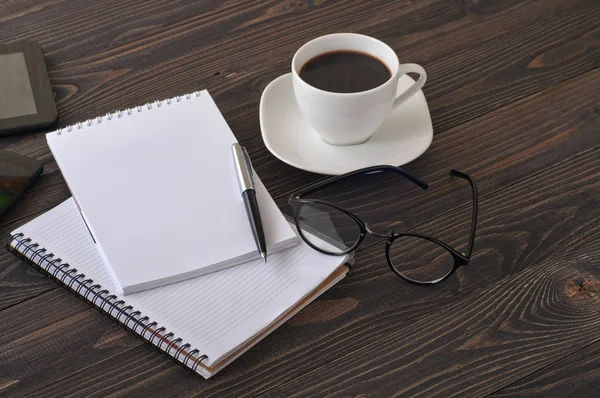 Il posto di lavoro con blocco note, penna e bicchieri da caffè — Foto Stock