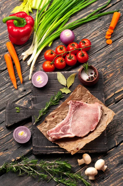 Raw fresh steak on the bone with vegetables — Stock Photo, Image