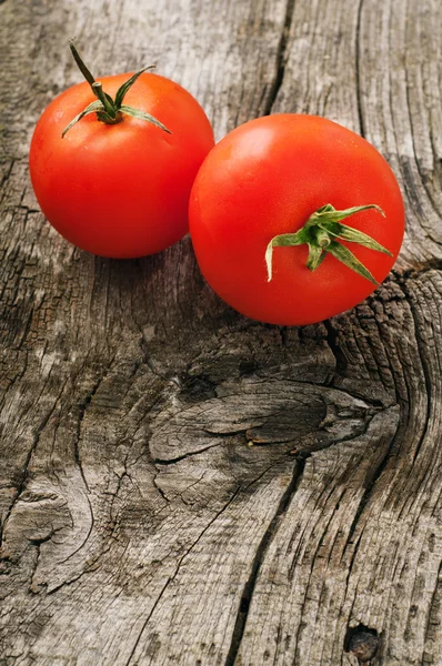 Tomate vermelho maduro no fundo de madeira — Fotografia de Stock