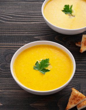 maydanoz yaprağı koyu ahşap yüzeyde balkabağı çorbası