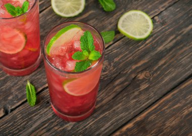 Two red cocktail with ice, lime and mint clipart
