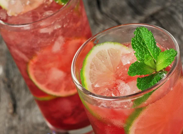 Nahaufnahme roter Cocktail mit Eis, Limette und Minze — Stockfoto