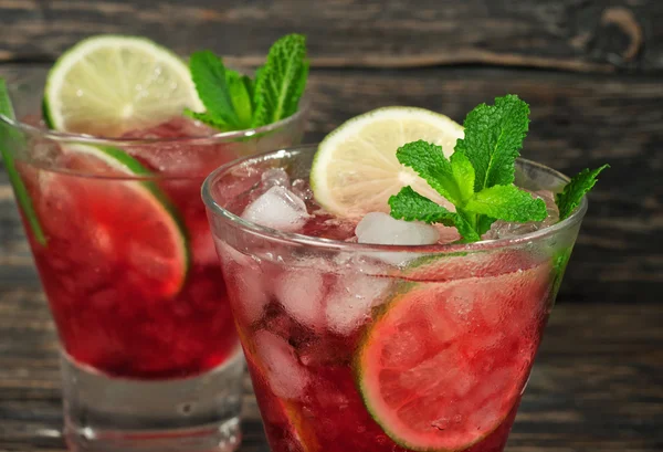 Closeup red cocktail with mint, lime and ice — Stock Photo, Image