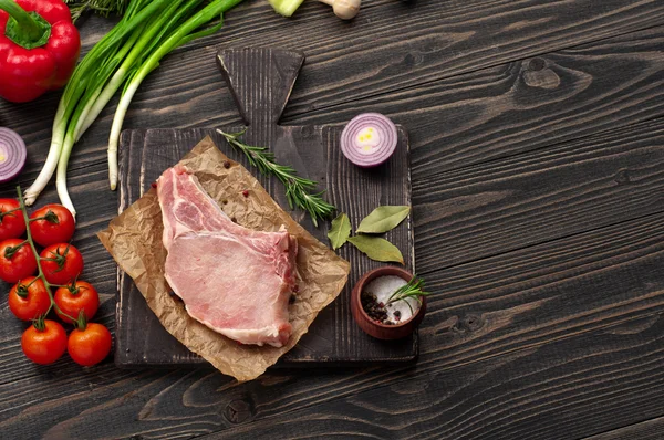 Trozo de carne fresca cruda en el hueso con verduras — Foto de Stock