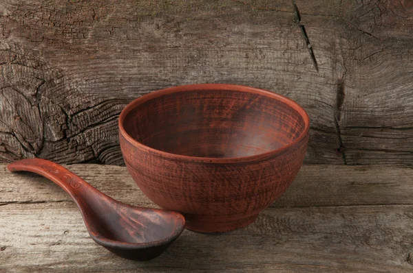 Empty clay bowl with spoon — Stock Photo, Image
