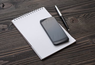 Masaüstünde smartphone, defter kalem ile