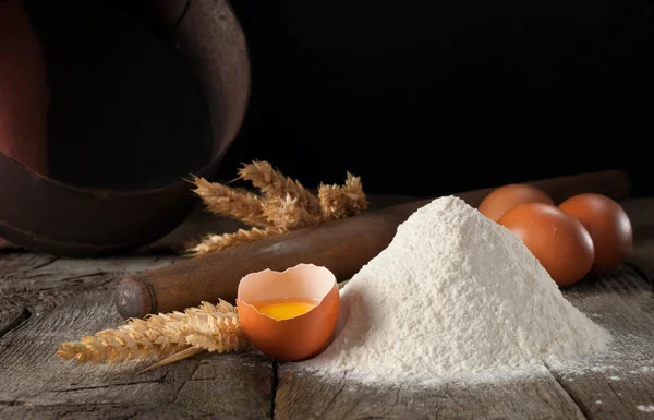 Primo piano di farina con uova crude marroni rotte — Foto Stock