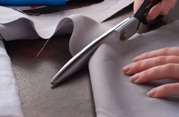 Closeup of a dressmaker cuts scissors cloth — Stock Photo, Image