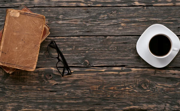 Gestapelde oude boeken, brillen en kopje koffie — Stockfoto