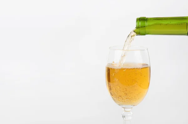 Pouring white wine from bottle into the wineglass — Stock Photo, Image