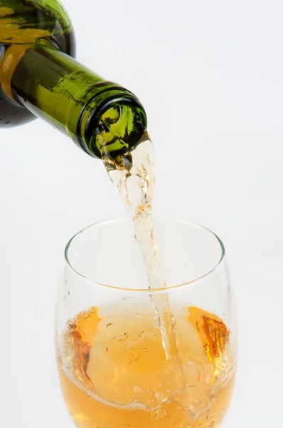 Pouring white wine from bottle into the wineglass — Stock Photo, Image