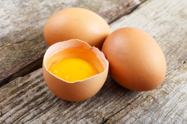 Tam ve kırılmış çiğ kahverengi yumurta. 