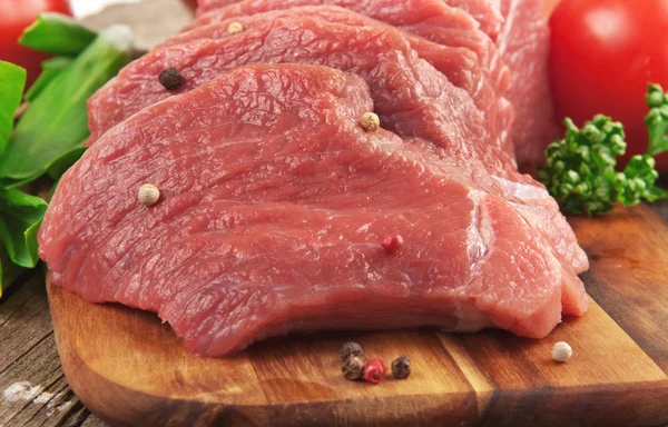 Portioned slices of raw meat on a cutting board. Fresh pieces of chopped  beef tenderloin close-up. Five juicy slices of beef. Ingredients for  preparin Stock Photo - Alamy