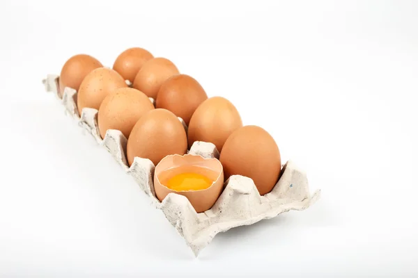 Gehele en gebroken rauwe bruine eieren in lade — Stockfoto