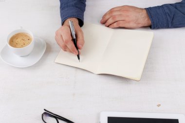 Bir defter beyaz masadaki adam yazıyor