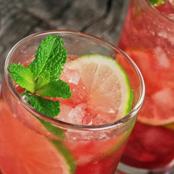 Roter Cocktail mit Eis, Limette und Minze — Stockfoto