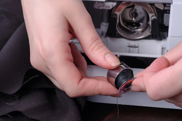 Seamstress replace bobbin in the sewing machine — Stock Photo, Image