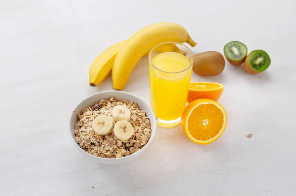 Granola, plátanos, vaso de jugo de naranja y kiwi — Foto de Stock