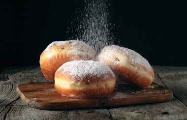 Üç donut ile pudra şekeri serpilir