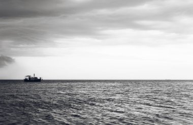 İnsanlar okyanusa Günbatımı ile ahşap tekne