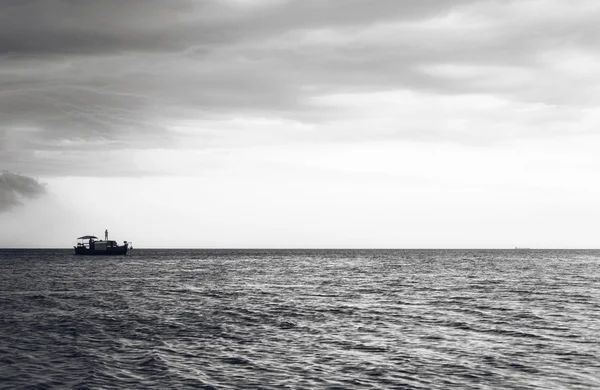 İnsanlar okyanusa Günbatımı ile ahşap tekne