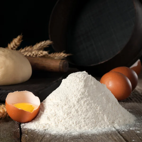 Punhado de farinha de trigo perto com ovos castanhos — Fotografia de Stock