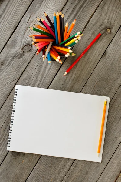 Open drawing pad with blank pages with colored pencils — Stock Photo, Image