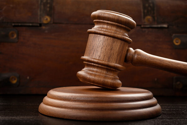 Judge hammer on brown wooden background