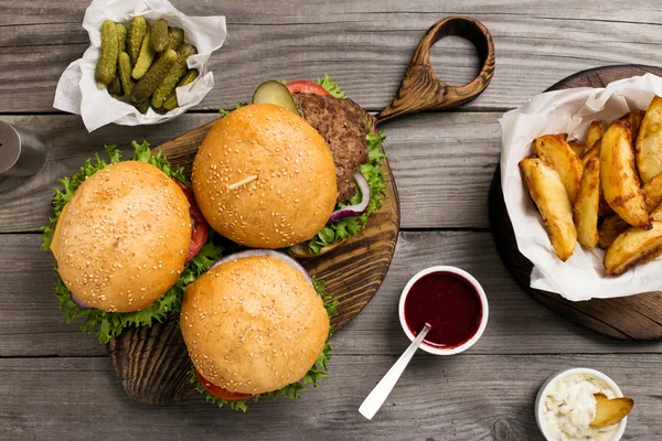 Different burgers on wooden board — Stock Photo, Image