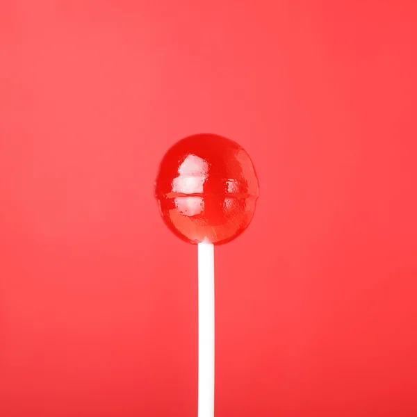 Червоний льодяник на червоному тлі — стокове фото
