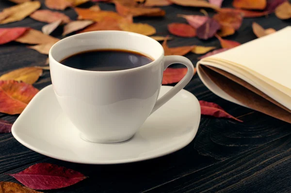 Kop koffie op houten tafel met herfst droge bladeren — Stockfoto