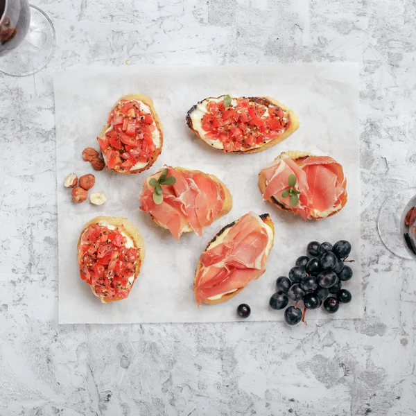 Different appetizers for wine on white paper — Stock Photo, Image