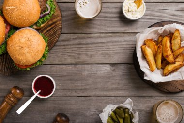 Çerçeve farklı hamburger, sosları, patates kızartması, turşu ve hafif b